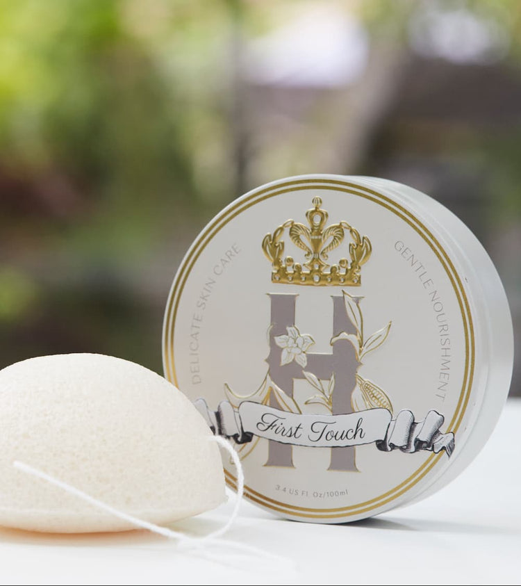 Royal Heir Botanicals First Touch Butter and a gentle Konjac sponge making up a First Touch ritual for a newborn baby. 